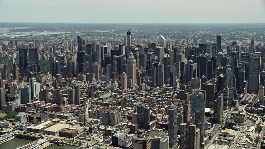 Aerial view of Hudson Yards and Hells Kitchen in Midtown Manhattan with high-rise buildings and train tracks seen during daytime