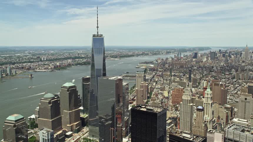 Aerial footage of One World Trade Center and the Hudson River in Lower Manhattan New York City on a partly cloudy day