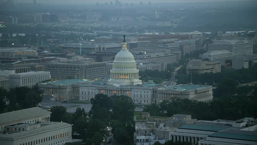 Aerial footage in twilight of the iconic United States Capitol building in Washington DC surrounded by haze and visited by tourists