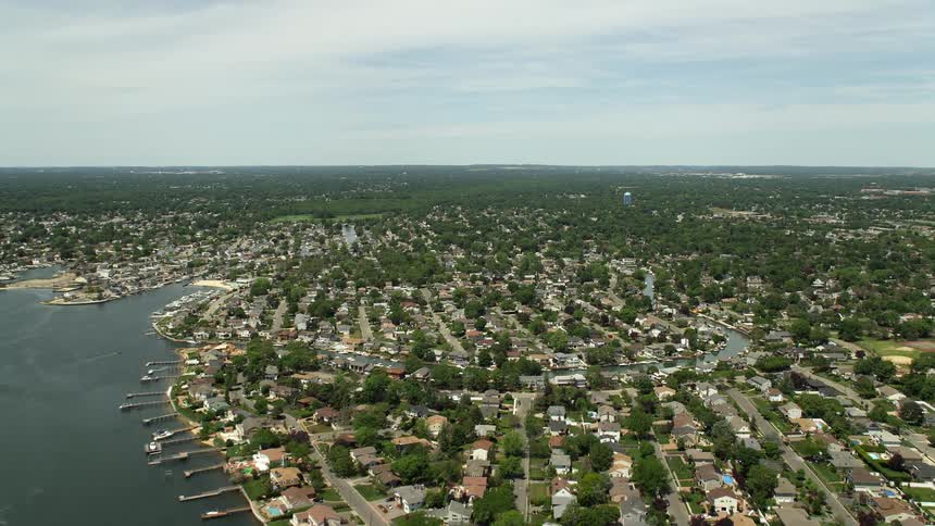 Approaching Massapequa from small marshy islands in South Oyster Bay this aerial footage showcases a suburban waterfront community in New York during summertime