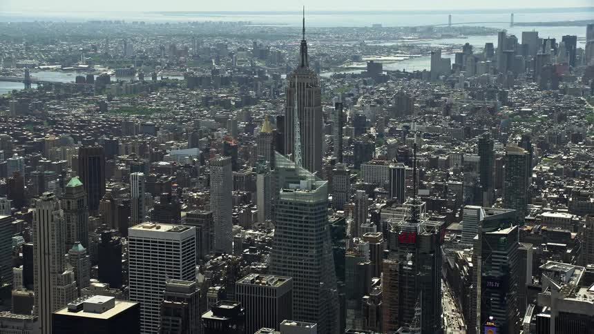 A breathtaking aerial view as we approach the iconic Empire State Building and Bank of America Tower in Midtown Manhattan New York City during a hazy day