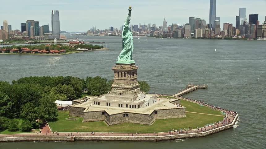 Aerial footage reveals the Statue of Liberty and Lower Manhattan skyline on a sunny day in New York City