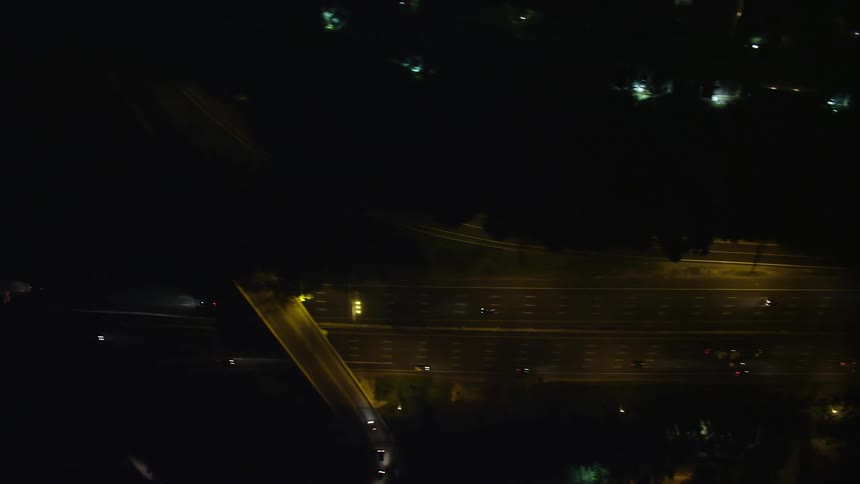 Nighttime aerial footage captures the smooth movement of cars and trucks on Interstate 95 in Alexandria Virginia under clear skies