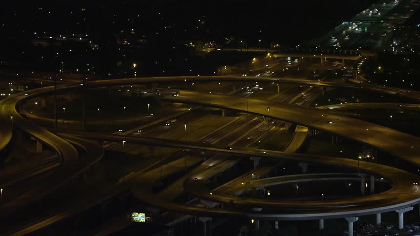 Approaching the Interstate 95 and Richmond Highway interchange the aerial footage captures light traffic on multiple highway overpasses in Alexandria Virginia at night