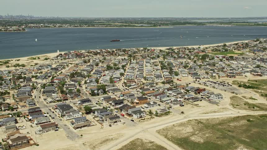 Aerial footage of residential neighborhoods in Breezy Point Queens near the water