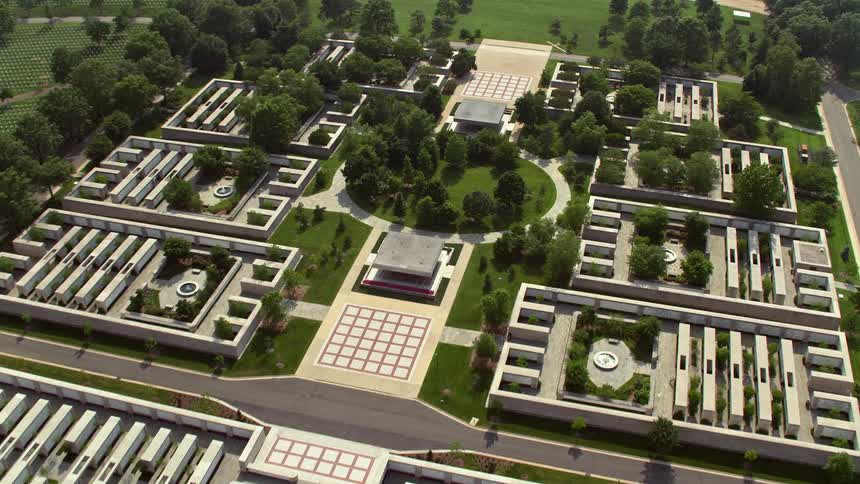 Approaching the historical and spiritual monument at Arlington National Cemetery in Washington DC during a hazy daytime aerial view