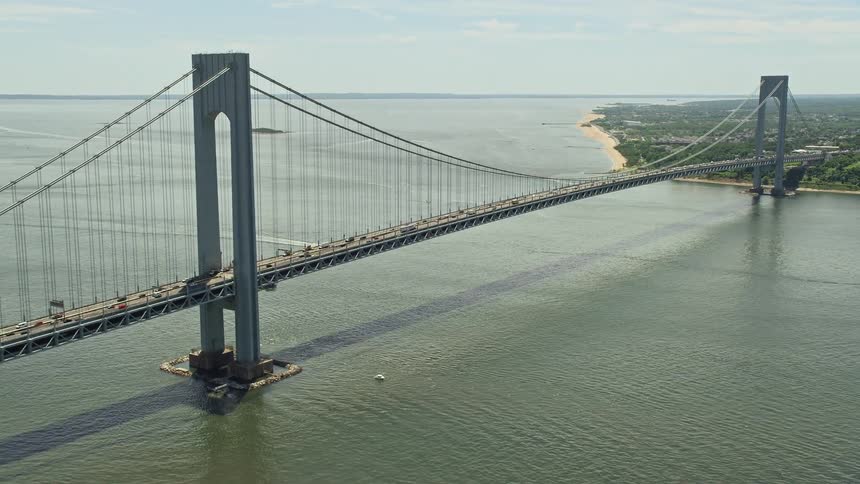 Aerial footage of approach and orbit of Verrazano-Narrows Bridge New York City on a partly cloudy day