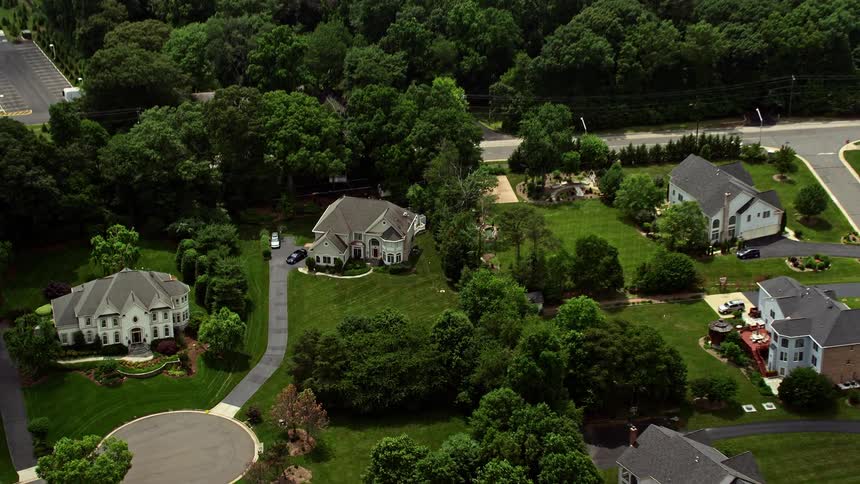A stunning daytime aerial view of luxurious upscale homes in Fairfax Station Virginia with partly cloudy skies and a birds eye view perspective