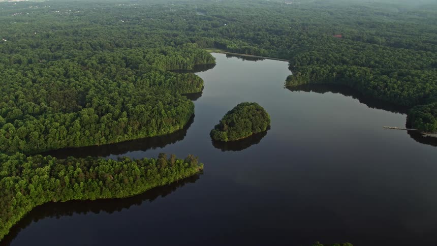 An aerial view during sunset captures the timberland shores of Burke Lake in Fairfax Station Virginia