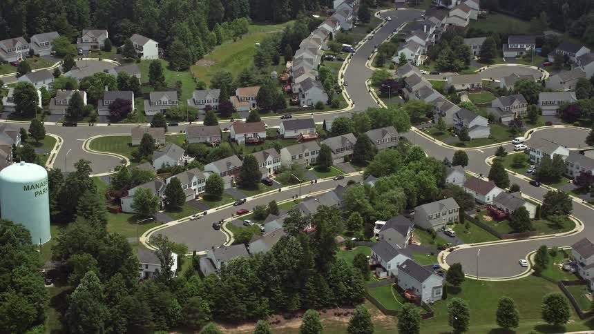 Aerial footage of a Manassas Virginia suburban neighborhood with parked cars on a partly cloudy day