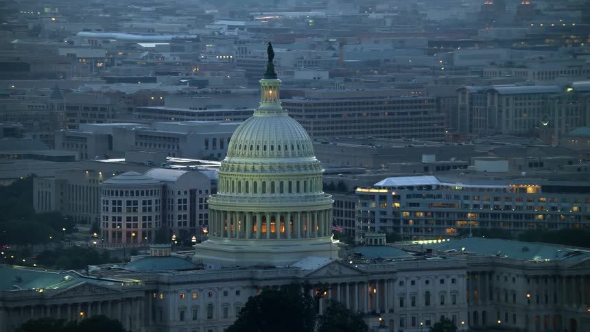 Aerial view of the iconic United States Capitol dome at twilight with surrounding office buildings in Washington DC