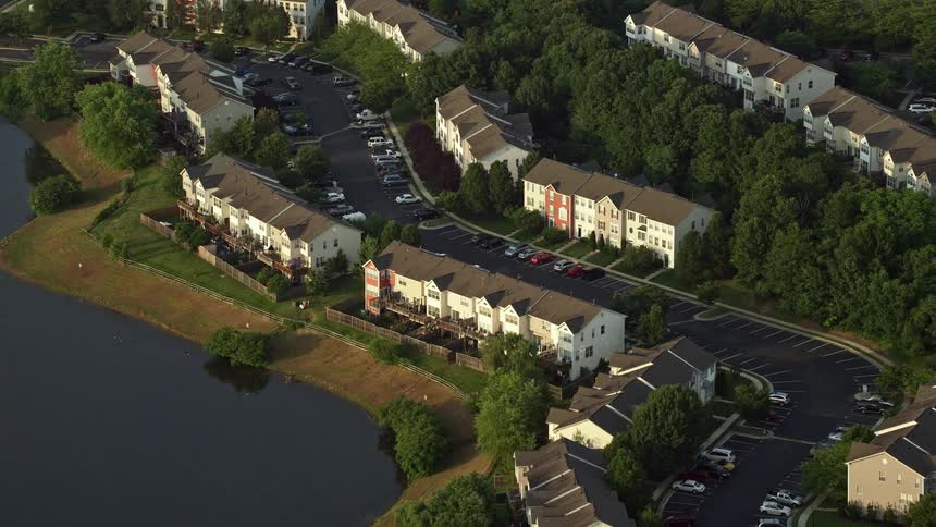 An aerial view at sunset of townhouses beside a pond in Manassas Virginia