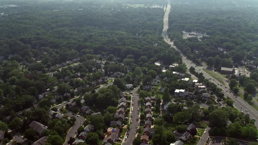 Approaching and flying over suburban homes next to Highway 50 in Arlington Virginia during daytime