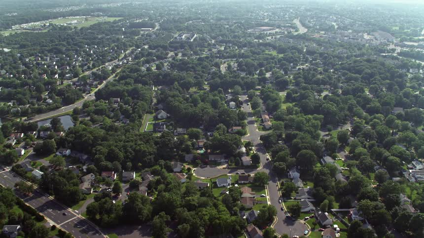 Approaching strip malls and stores in Manassas Virginia aerial footage shows flyover of suburban neighborhoods and retail centers