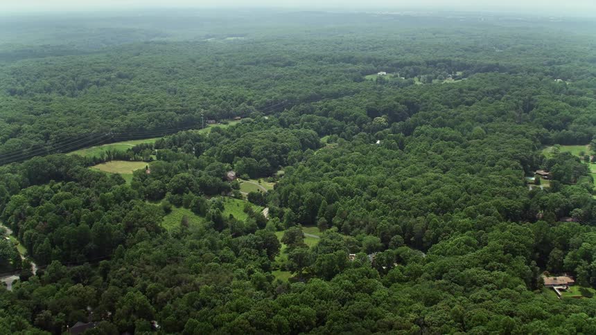 Aerial footage over a forest in Fairfax Station Virginia featuring a few upscale homes