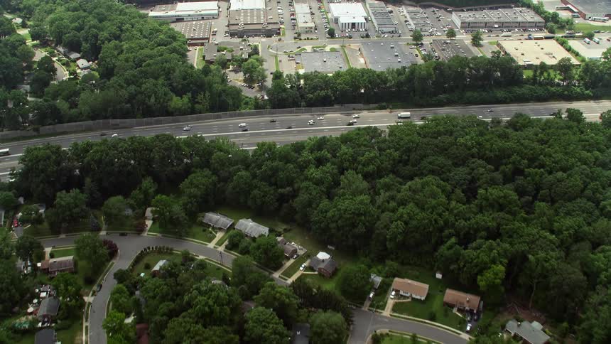 Aerial footage of suburban homes and I-495 in Springfield VA during the summer