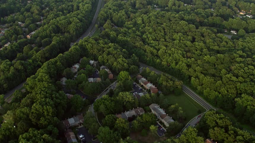 A sunset aerial flyover of a suburban area in Springfield Virginia featuring town houses row houses power lines and trees