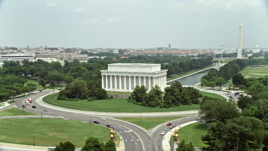 A stunning daytime aerial shot of Washington DC circling around Lincoln Memorial to reveal the breathtaking Reflecting Pool and iconic Washington Monument