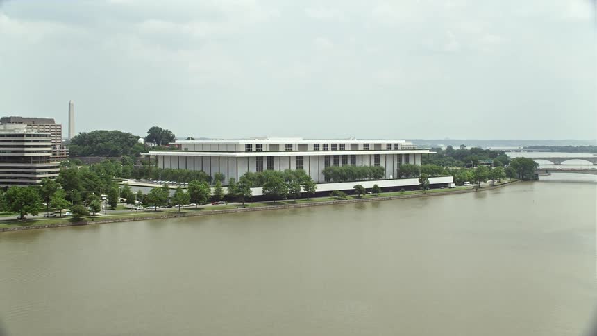 Approaching the John F Kennedy Center for the Performing Arts in Washington DC on a sunny day with a clear view of the Potomac river; a perfect representation of the citys culture and entertainment scene
