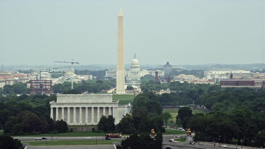 Captivating aerial footage of the United States Capitol Washington Monument and other iconic structures with a hazy backdrop of the Lincoln Memorial in the daytime