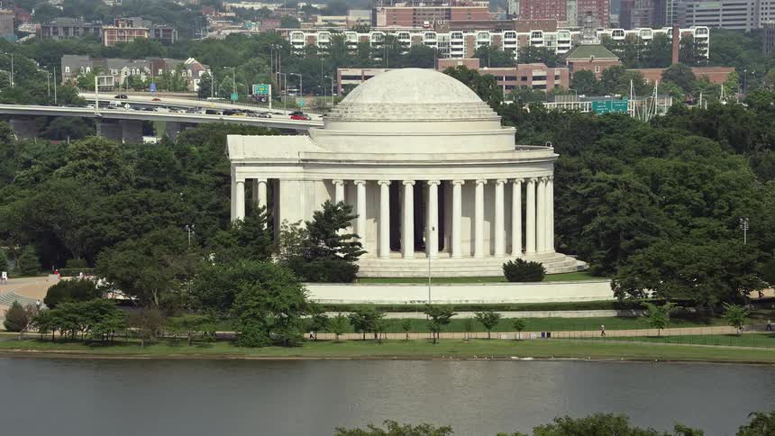 Approaching the iconic Jefferson Memorial in Washington DC on a bright sunny day during spring or summer filmed from an aerial 