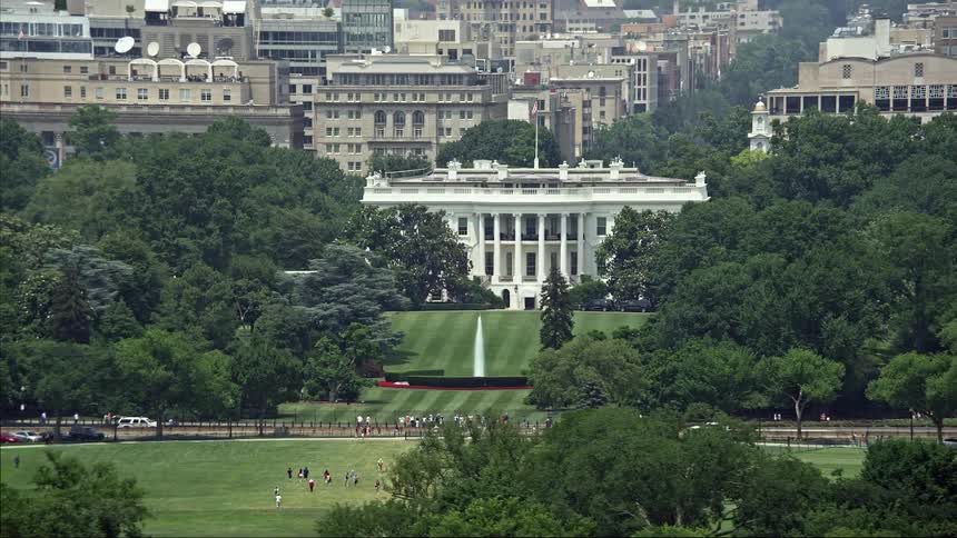 An aerial view of The White House and South Lawn in Washington DC during summertime with the iconic structure and fountain in view