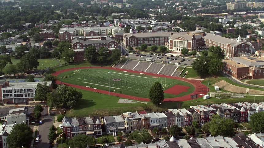This is an aerial footage of McKinley Technology High Schools football field in Washington DC during a sunny day showcasing the schools athletic facilities and learning environment