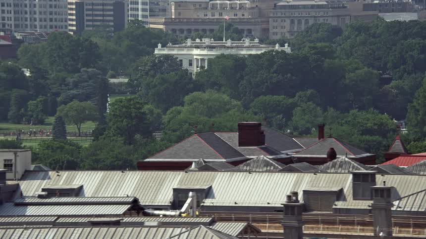 A sunny aerial view of the White House partially hidden by trees offering a famous landmarking sightseeing opportunity in Washington DC during Summer