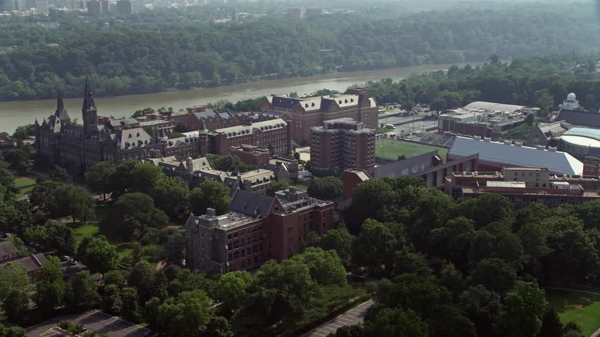 Captivating aerial footage of Georgetown University campus surrounded by the serene Potomac River in Washington DC during the day
