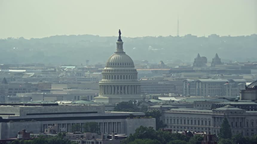 A stunning aerial view of the United States Capitol and Thomas Jefferson Building domes in Washington DC on a hazy day