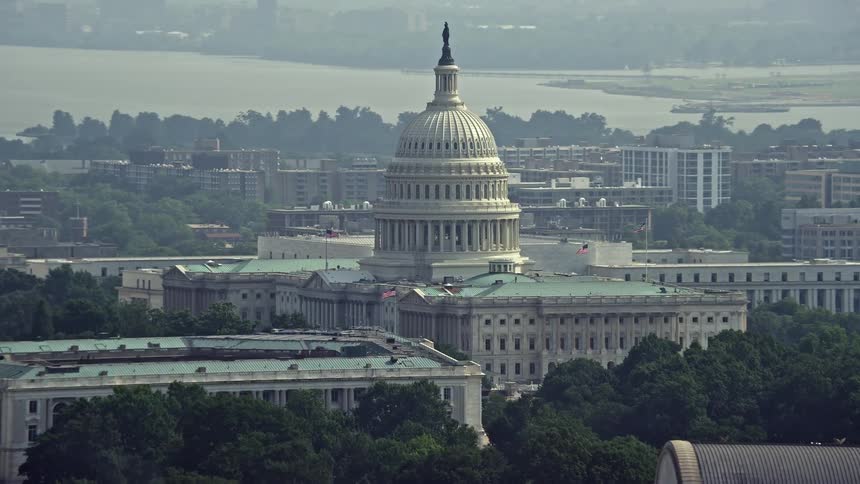 Aerial footage of the iconic North Side of the United States Capitol in Washington DC during a hazy summer day