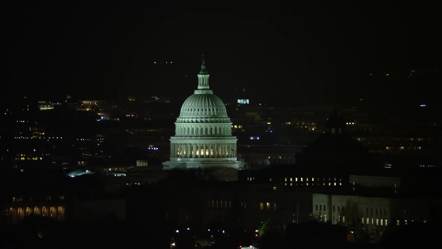 Night aerial footage of the United States Capitol and Thomas Jefferson Building domes iconic structures representing the government and education in Washington DC