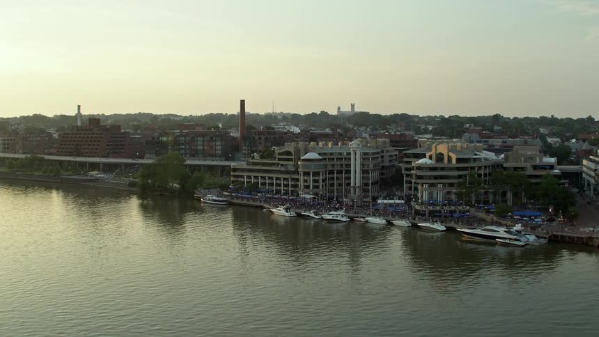 Aerial footage approaching Ritz-Carlton Residences and Washington Harbour by the Potomac River in Georgetown Washington DC during sunset