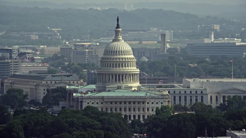 Aerial orbiting shot of the United States Capitol building in Washington DC during the summertime