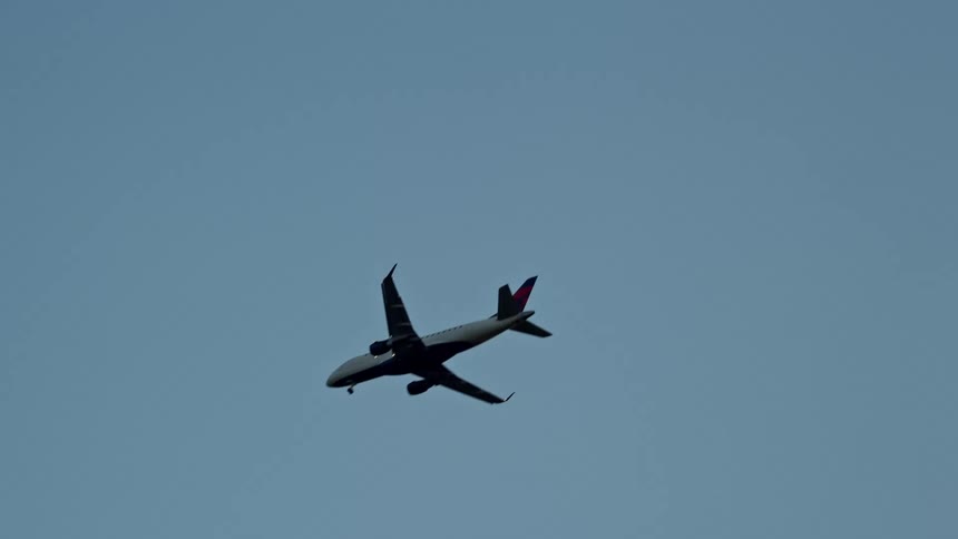 During a Washington DC sunset an aerial video tracks a commercial jet flying overhead