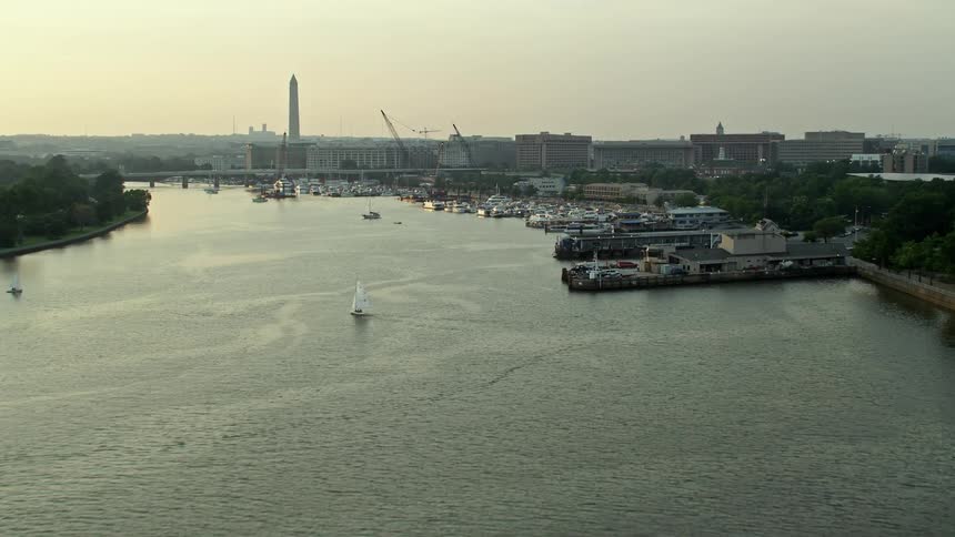 Approaching sailboats and a ferry on Washington Channel near the Washington Monument during sunset in Washington DC