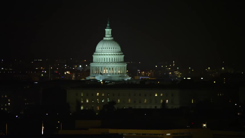 A night-time aerial view of the iconic United States Capitol building in Washington DC
