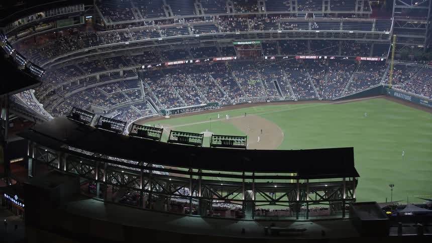 Approaching aerial view of baseball game in progress at Nationals Park in Washington DC at night