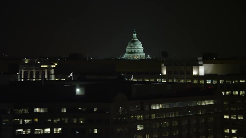 Aerial footage capturing the iconic US Capitol dome and office buildings in Washington DC at night