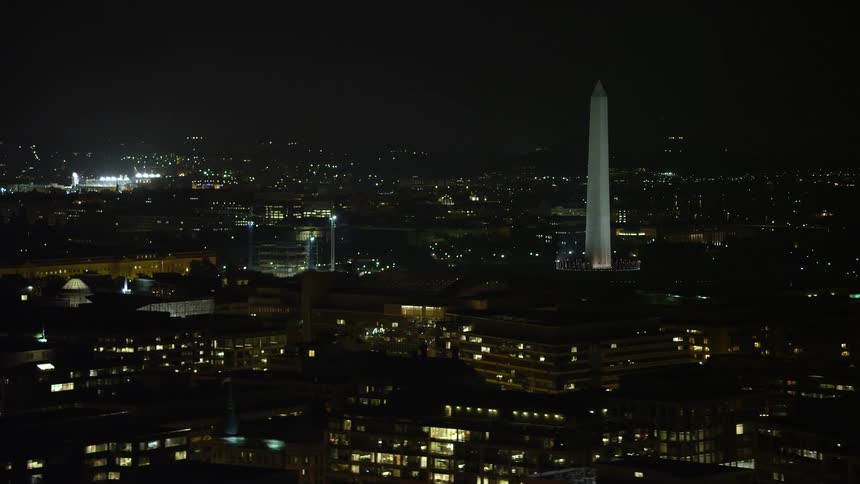 Aerial footage of Nationals Park and the Washington Monument with glowing lights in Washington DC at night