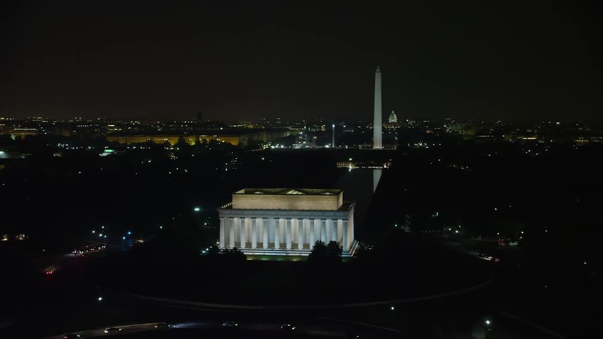 A stunning aerial view of the illuminated Lincoln Memorial Washington Monument and United States Capitol at night in Washington DC
