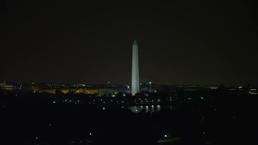 Aerial footage of the Washington Monument at night showcasing the iconic structure and surrounding clear skies