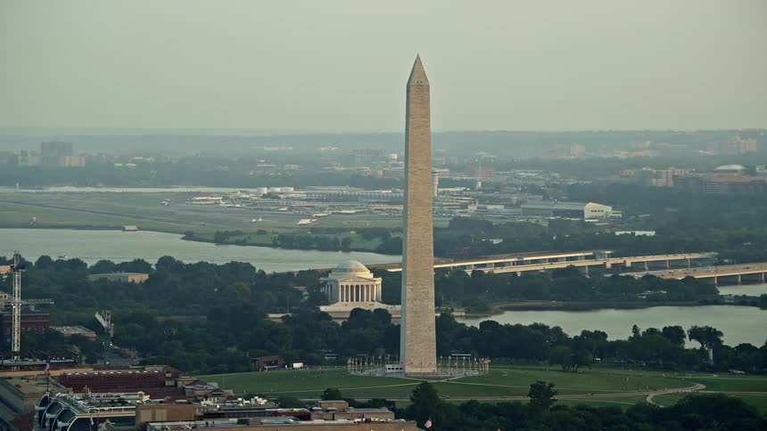 Aerial footage of Washington Monument and Jefferson Memorial at sunset with Ronald Reagan Airport visible in the background