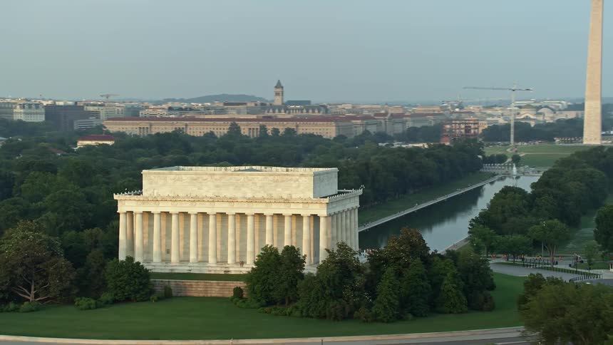 A stunning aerial shot of the Lincoln Memorial reflecting pool and Washington Monument revealed during sunset in Washington DC
