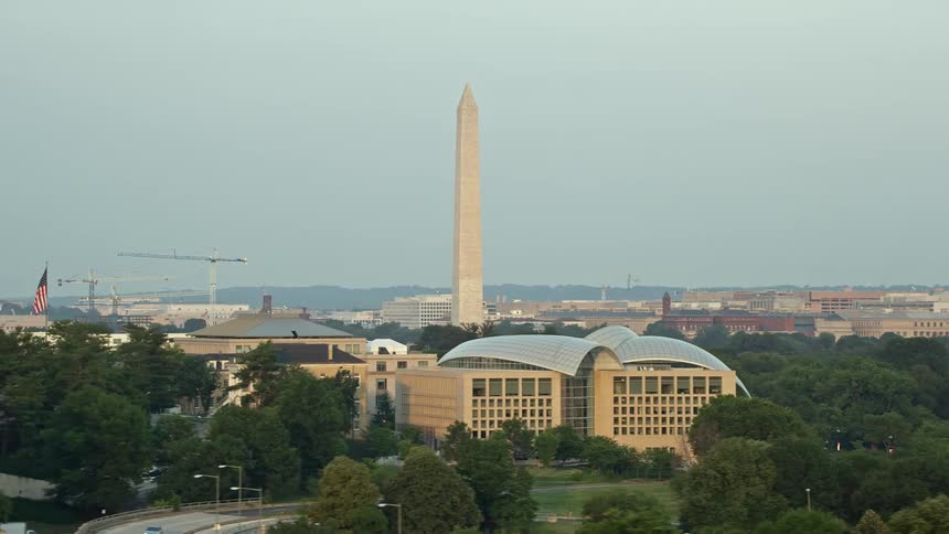 Aerial view of the iconic Washington Monument at sunset showcasing the nearby United States Institute of Peace and bustling city life