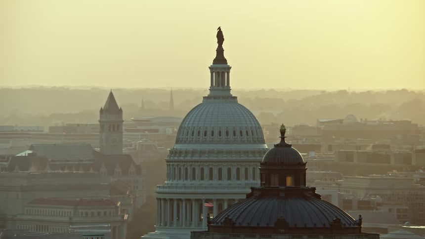 A stunning aerial view at sunset of the United States Capitol and Thomas Jefferson Building domes in Washington DC
