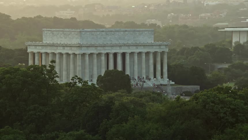 Aerial footage of tourists gathered on the steps of the Lincoln Memorial during sunset in Washington DC