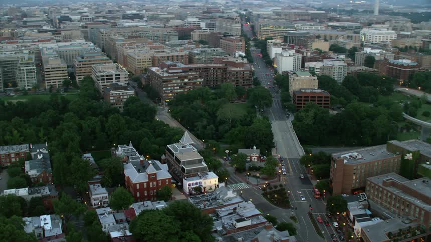 Aerial footage of traffic flowing along the forking street passing through Georgetown Washington DC at twilight