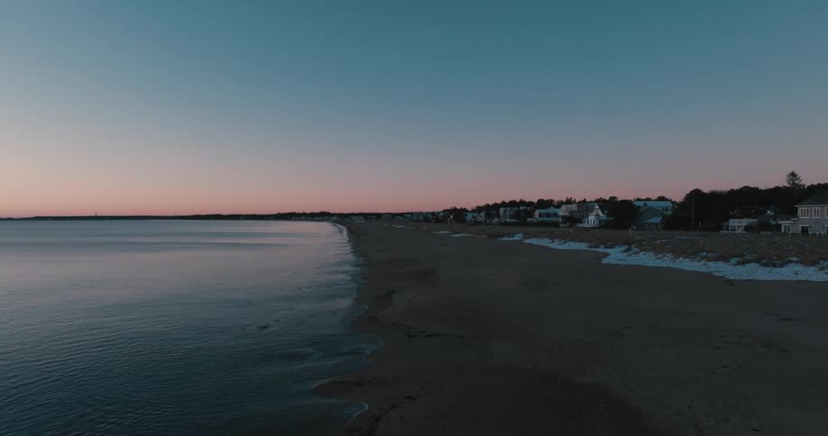 Camera moves across beach at sunrise in winter