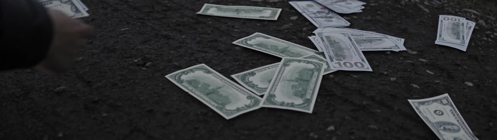 Someone picking up us dollar bills